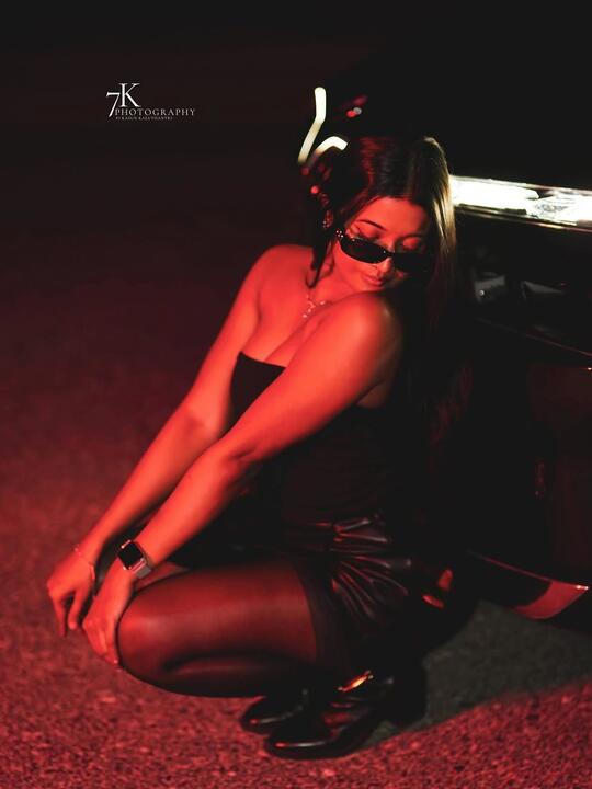 Crouched pose under a deep red wash