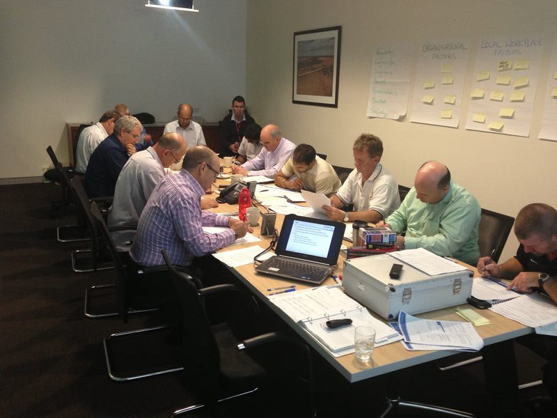 Adult participants working through course material around a boardroom table