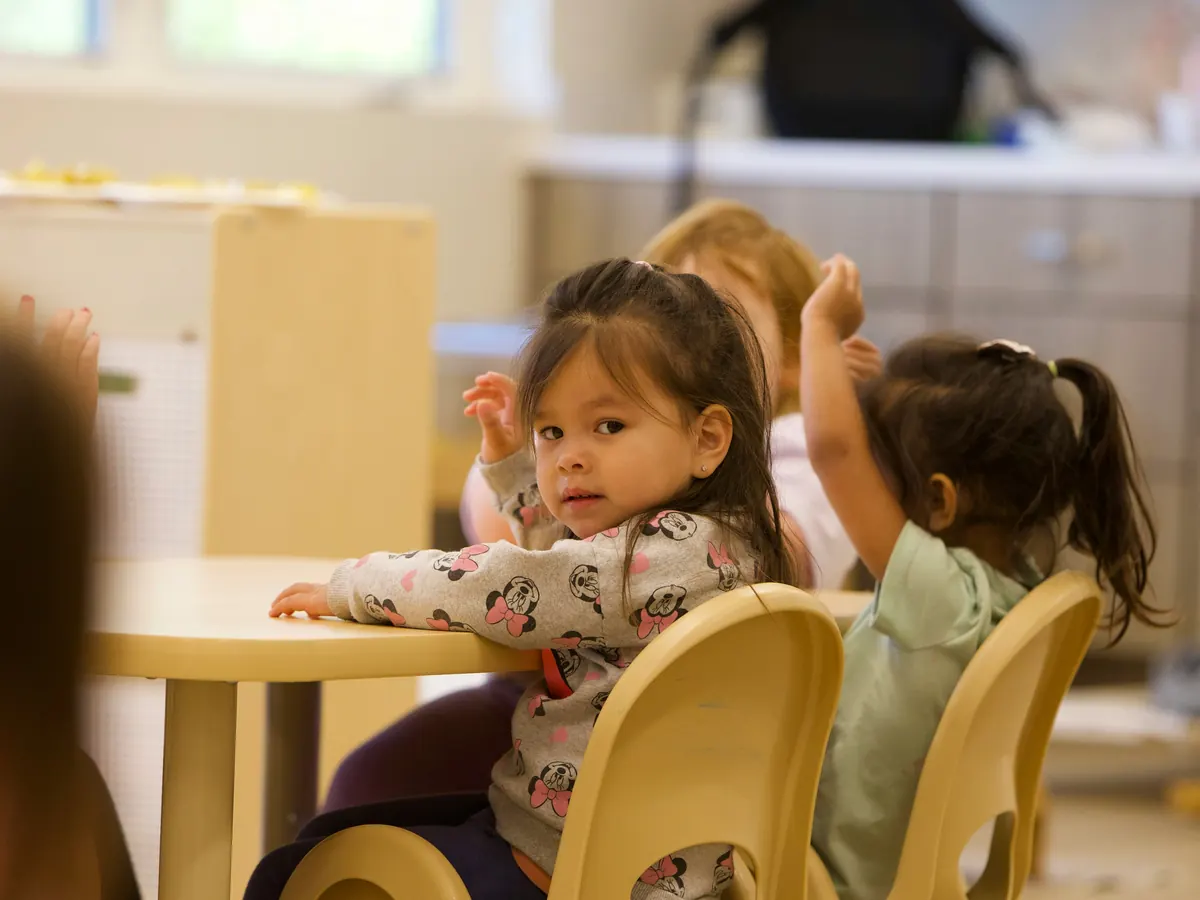 A young child sitting at a low table in a calm, home-like room