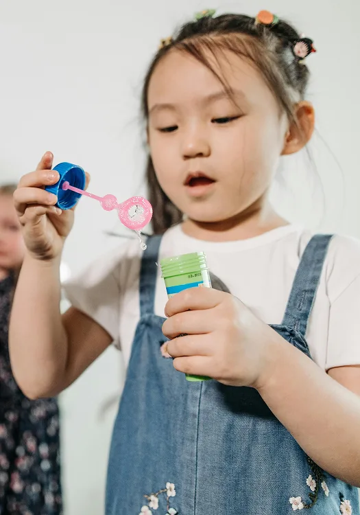 A child concentrating on a small toy held in both hands