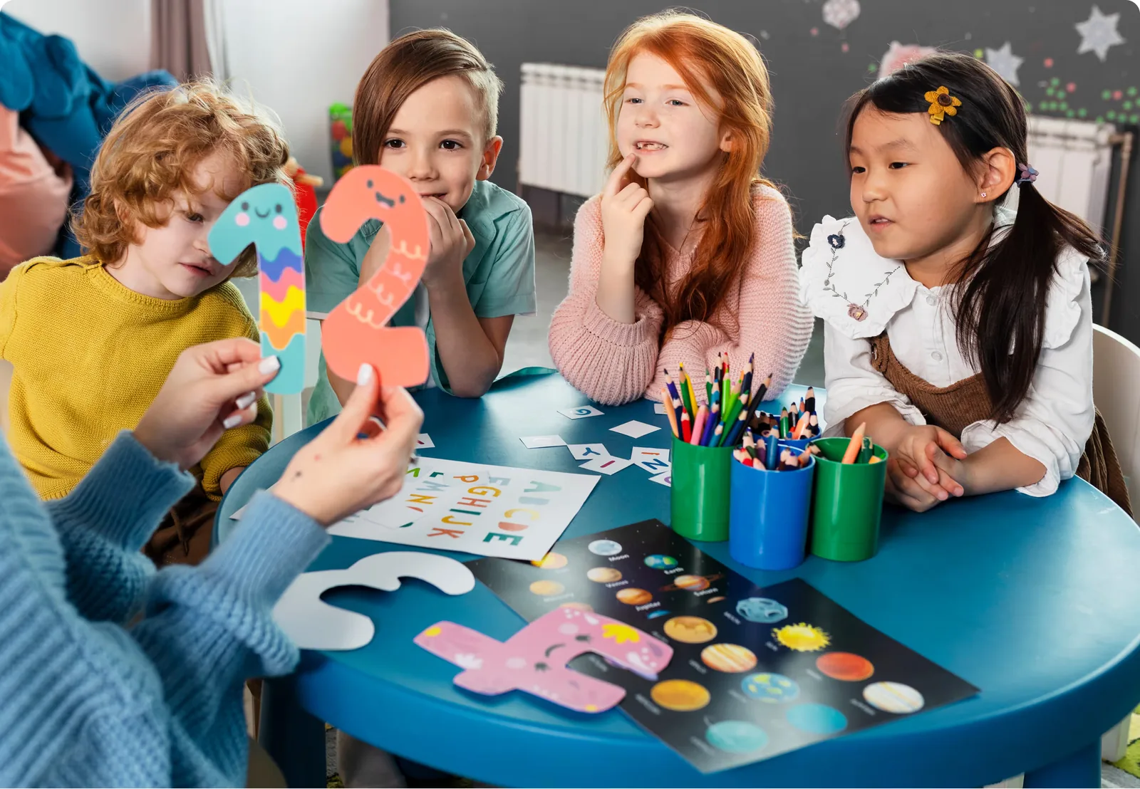 Children and an educator working together at a craft table