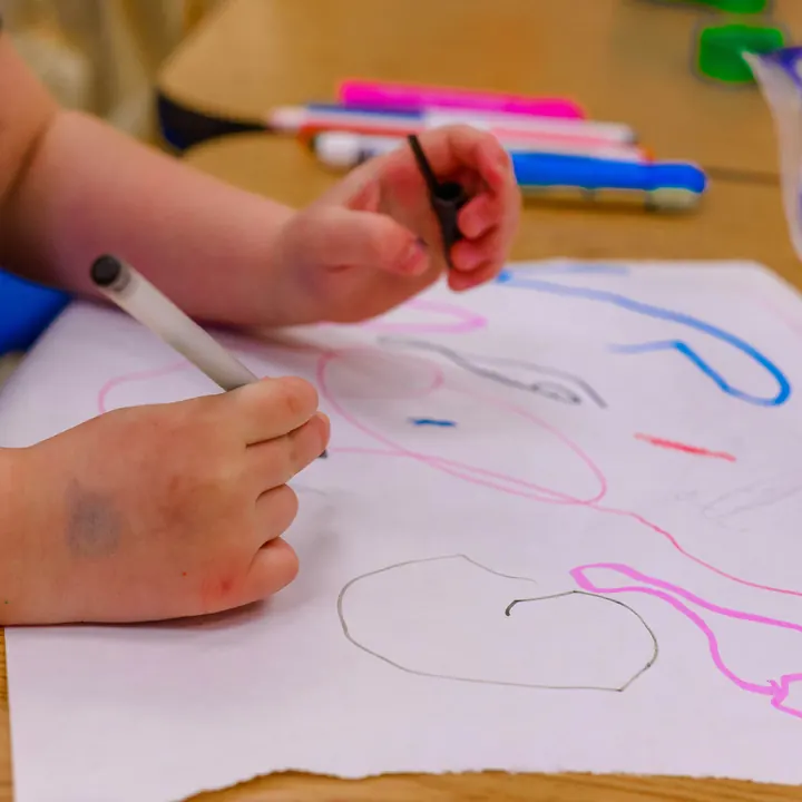 Close-up of a child drawing with coloured markers