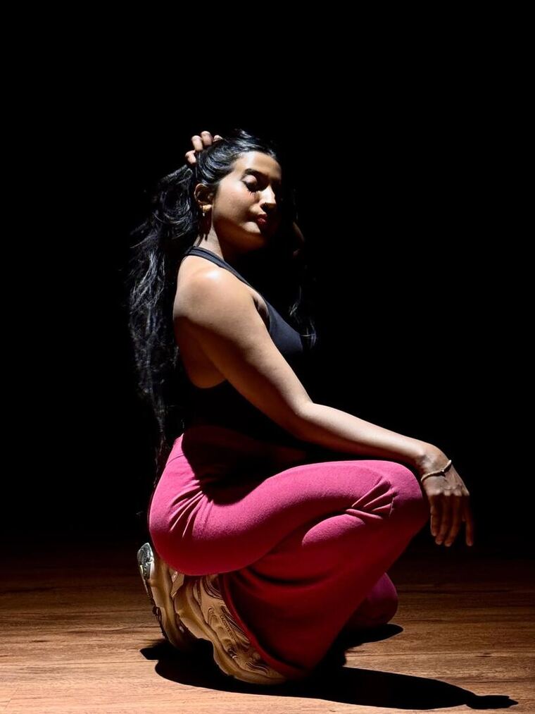 Maneesha mid-phrase under a single light