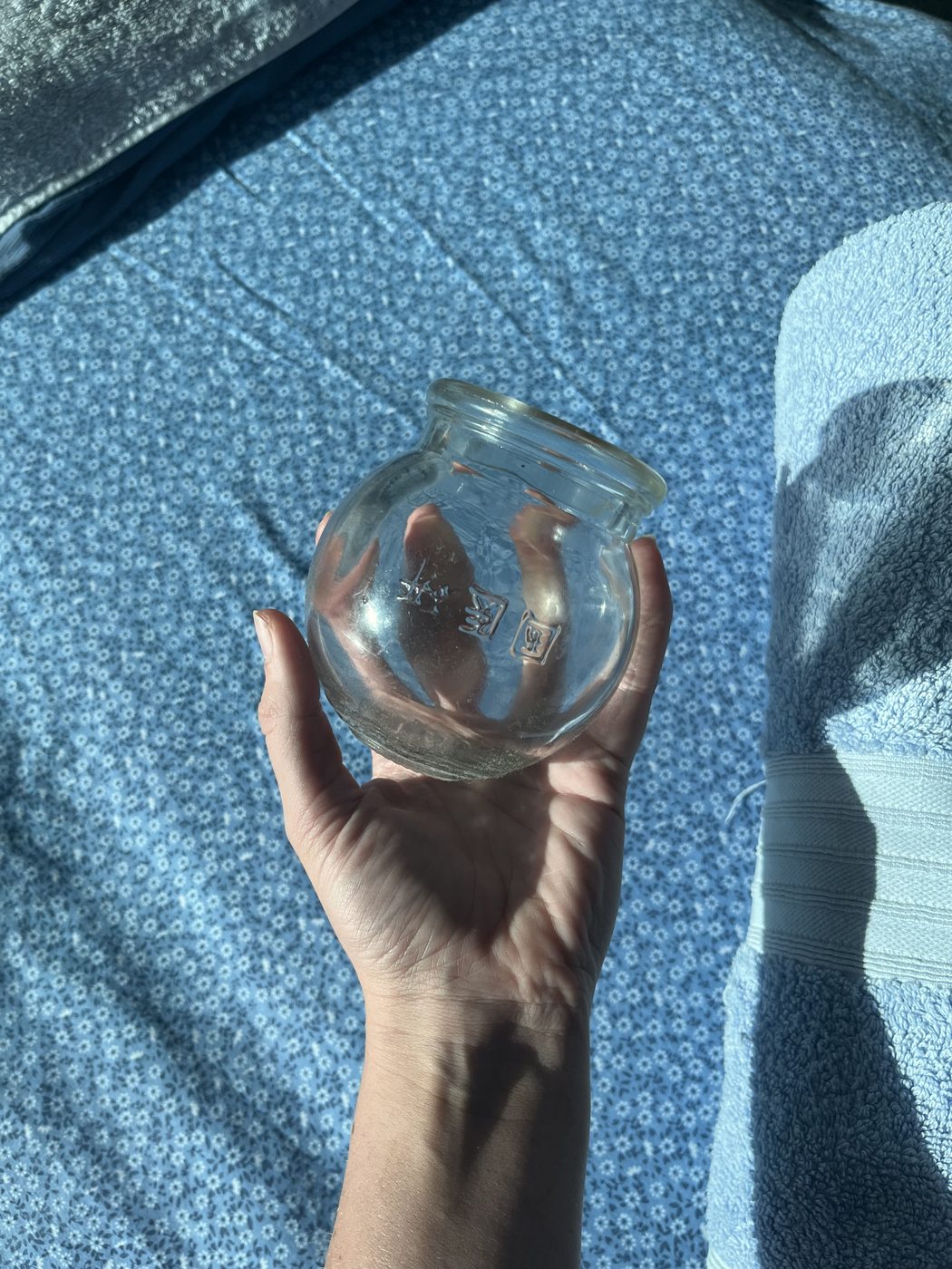 Glass cupping vessel held before a cupping treatment