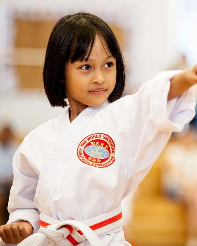 A junior WSKF student holding a focused punch during class