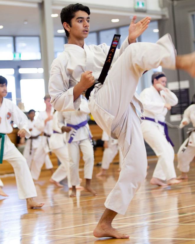 A senior student delivering a high kick during a WSKF Australia class